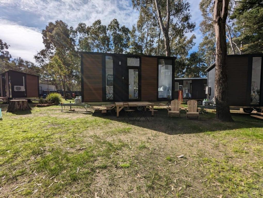 a tiny house in a park with a tree at Tiny House 4 at Grampians Edge in Dadswells Bridge