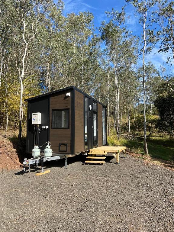 a tiny house sitting on a gravel lot at Hill Creek 2 Tiny House in Perwillowen