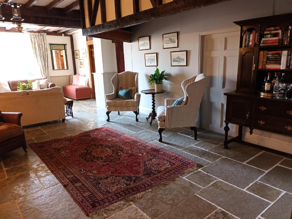 sala de estar con sillas y alfombra en Baskerville House en Clyro