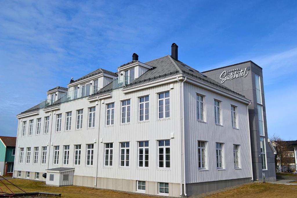 ein großes weißes Gebäude mit einem Schild drauf in der Unterkunft Andenes Suitehotel in Andenes