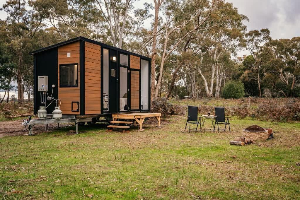 a tiny house with a picnic table and chairs at Northern Grampians Getaway in Dadswells Bridge