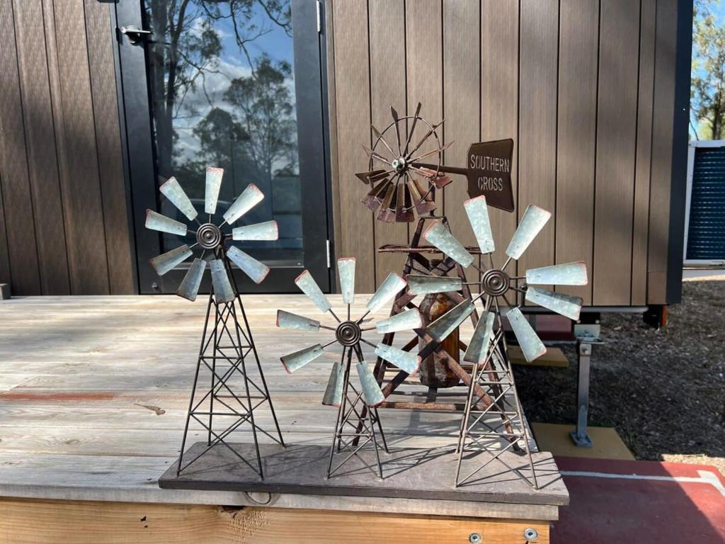 a group of windmills sitting outside of a building at 5 Acre Retreat in Jimboomba