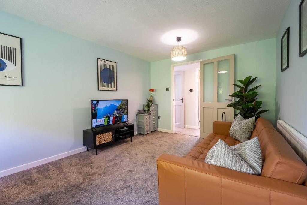 a living room with a couch and a tv at Park View- 2 bed apartment close to East Surrey Hospital in Salfords