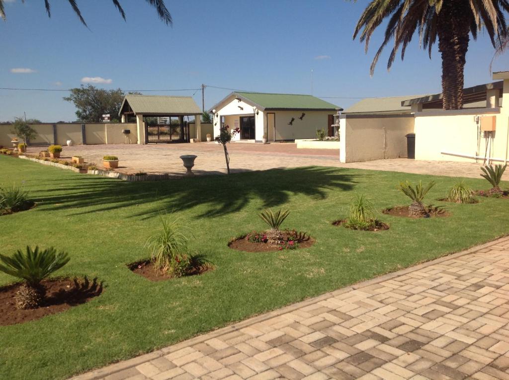 un gruppo di piante in un cortile con una casa di Marang Gardens Lodge a Mahikeng