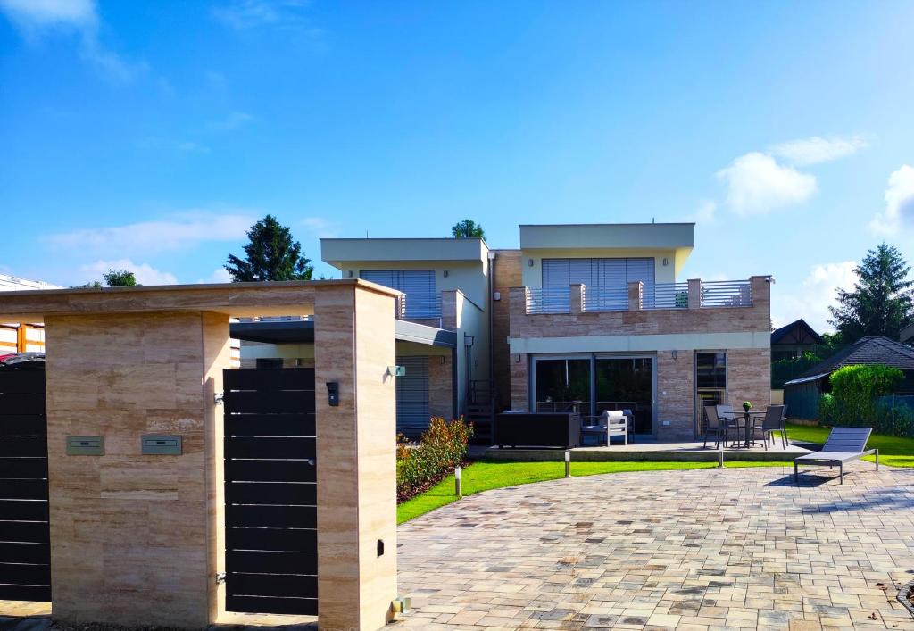 a house with a patio in front of it at Balatonkenese Sunshine Villa in Balatonkenese