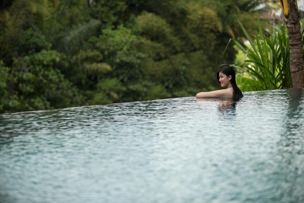 a woman sitting in a pool of water at Dwaraka The Royal Villas in Ubud