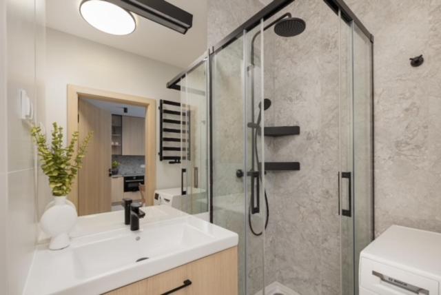 JTB Apartamenty Centrum في شتتين: حمام مع دش ومغسلة ودش