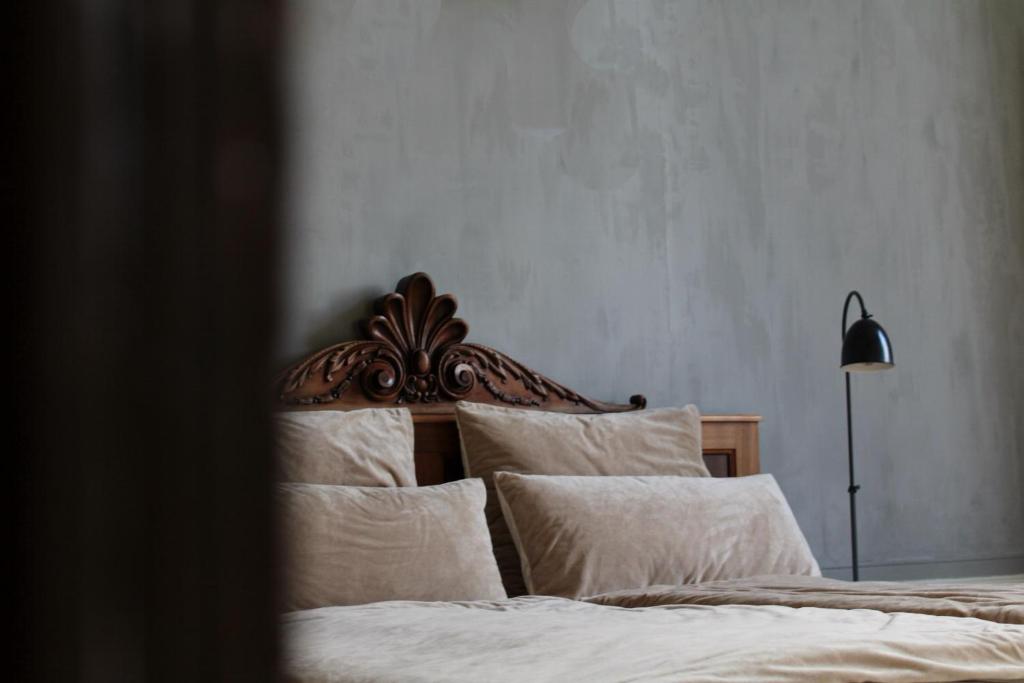 ein Schlafzimmer mit einem Bett mit weißer Bettwäsche und einer Lampe in der Unterkunft Logies aan de Dam in Middelburg