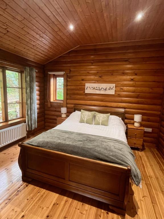 a bedroom with a bed in a wooden cabin at Romantic Log Cabin With Hot Tub in Leominster