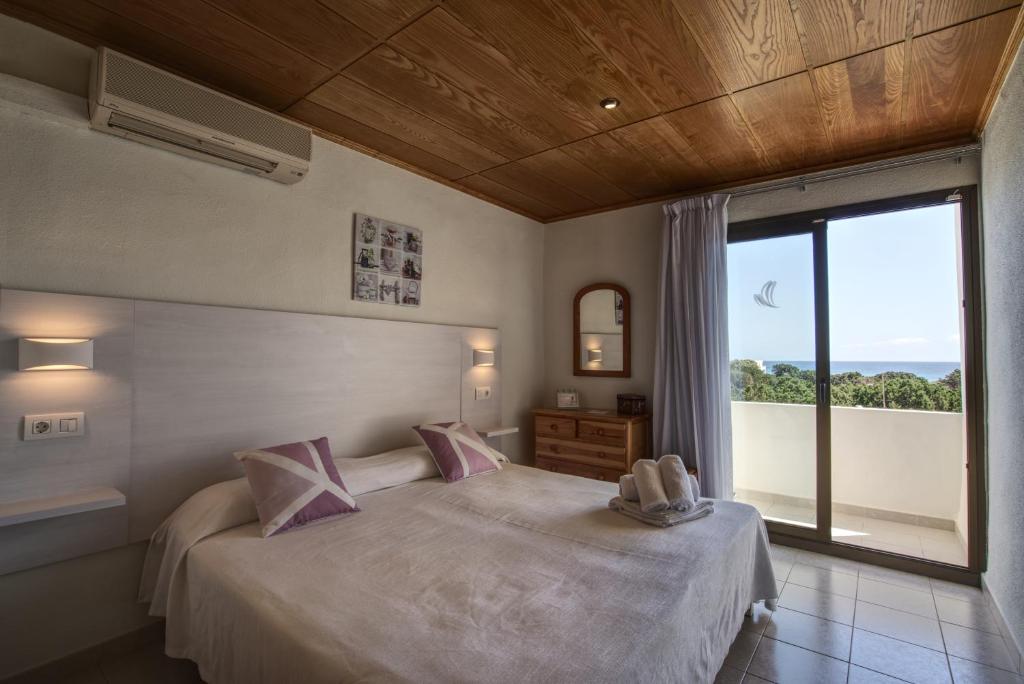 a bedroom with a bed and a large window at Hotel Rosamar - Emar Hotels in Es Pujols