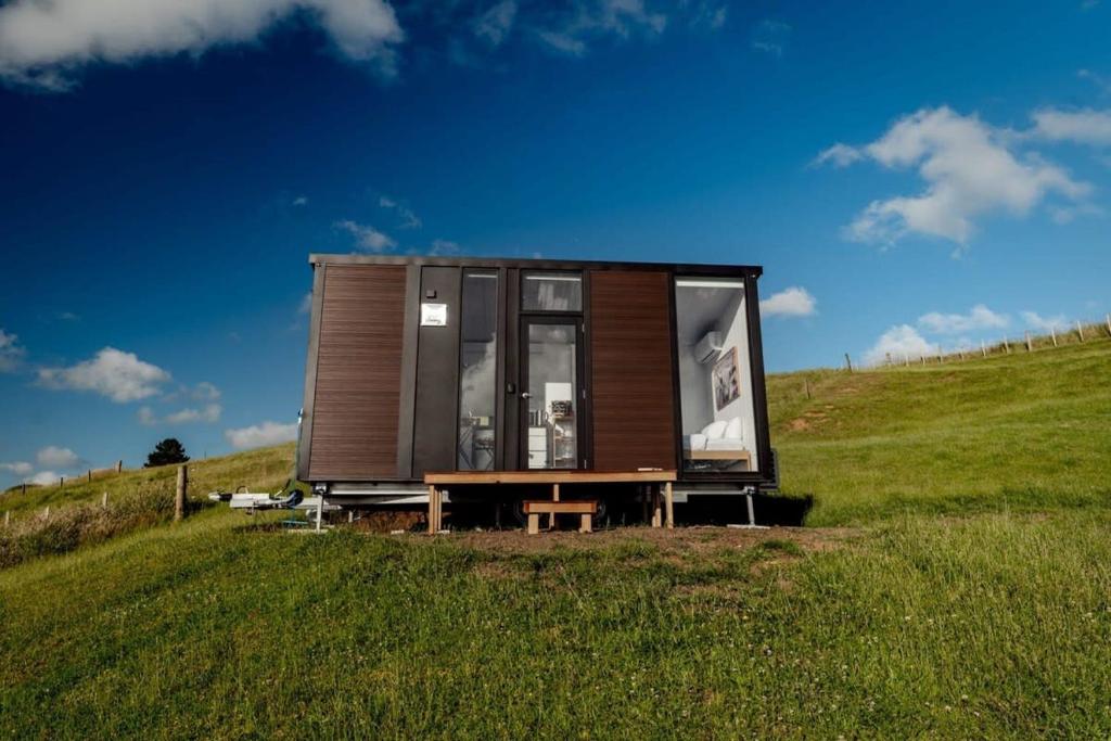 a tiny house on a hill in a field at Mighty Tiny House 1 in Ruawaro
