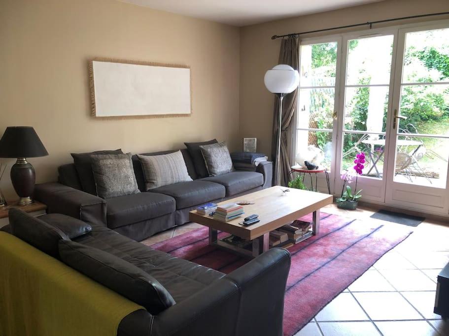 a living room with a couch and a coffee table at Maison de ville avec jardin centre Montfort l&#39;Amaury in Montfort-lʼAmaury