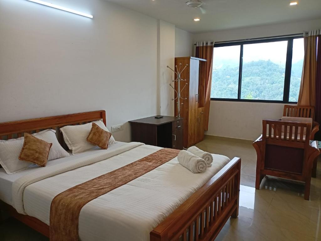 um quarto com uma cama grande com uma cadeira e uma janela em Silver Munnar em Munnar