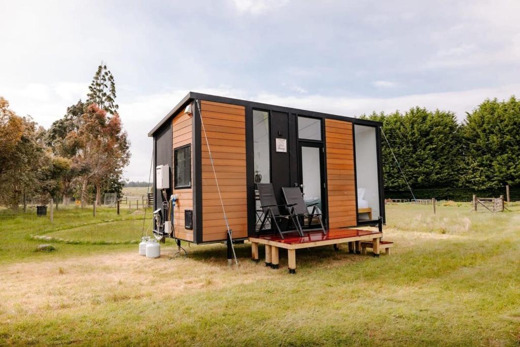 a tiny house sitting on top of a field at Harrington's on the Terrace - Luxmore in Te Anau