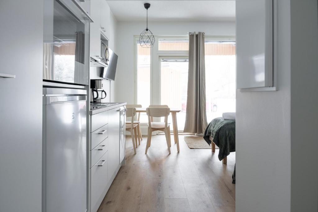 a kitchen with white cabinets and a table in a room at Studio Brita in Helsinki