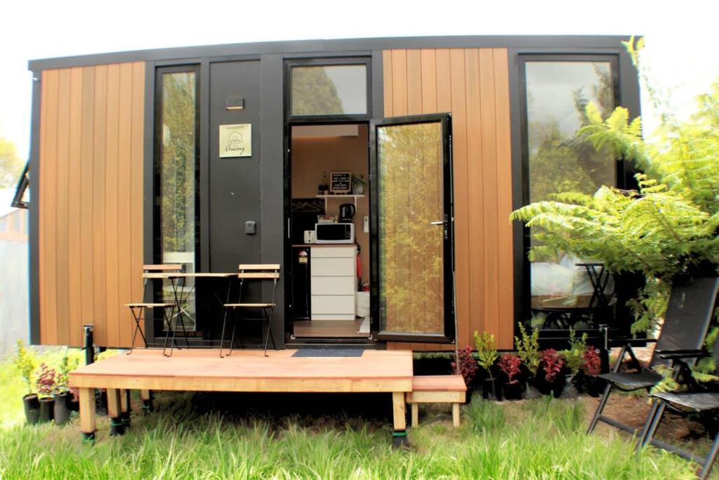 une petite maison avec une table dans la cour dans l'établissement Dairy Flat Farm Cabin 2, à Waitoki