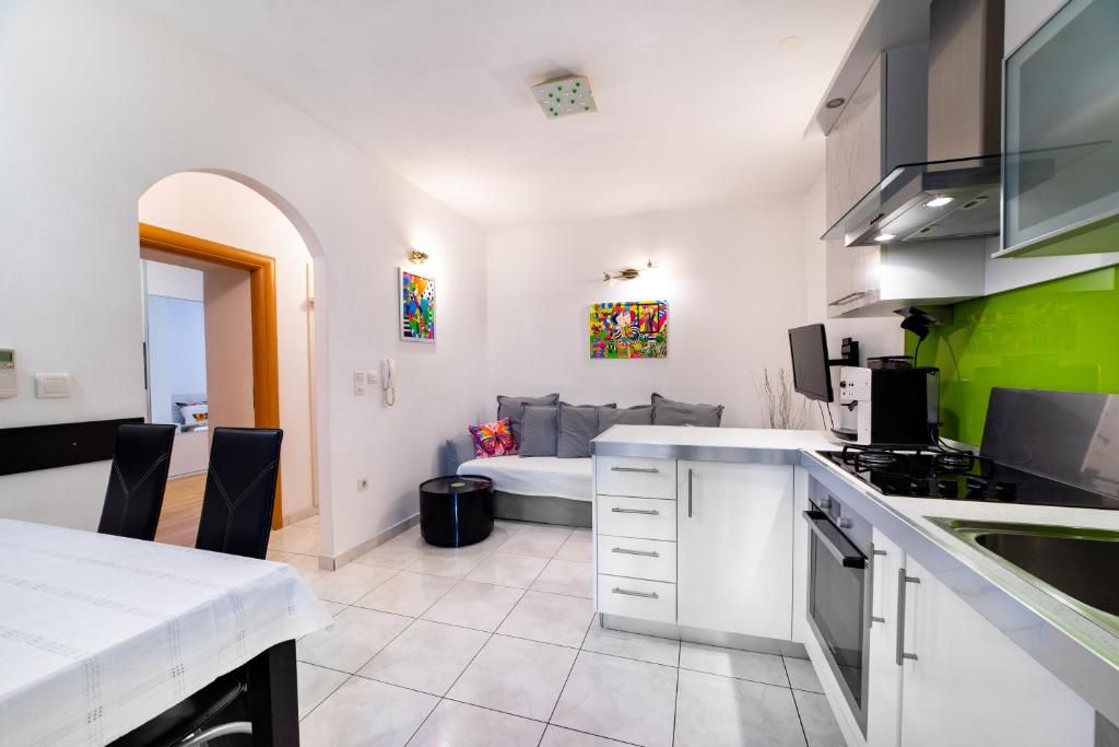 cocina y sala de estar con sofá en el fondo en Apartment Happy in Split center 10 min walk from Bačvice beach, en Split