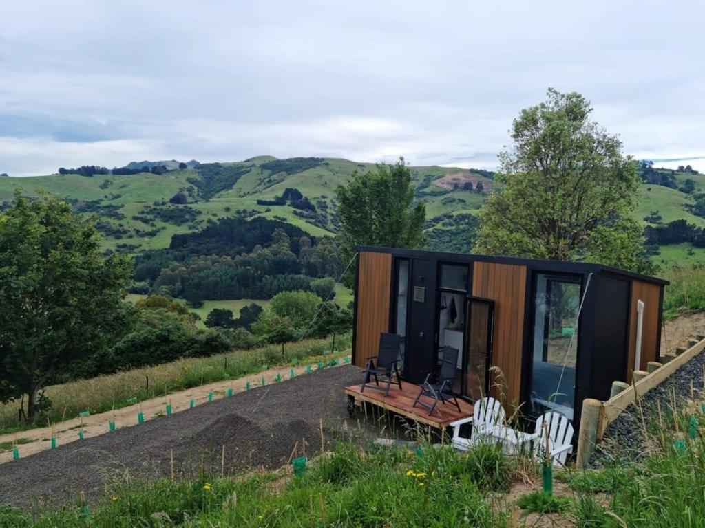 a tiny house sitting on top of a hill at Kukupa Puni at Akaroa Lavender in Duvauchelle