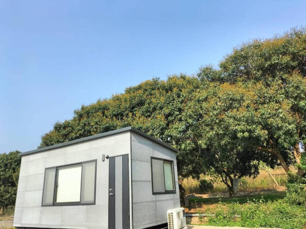 una casa pequeña sentada frente a un árbol en The Dawn 2, en Kaohsiung