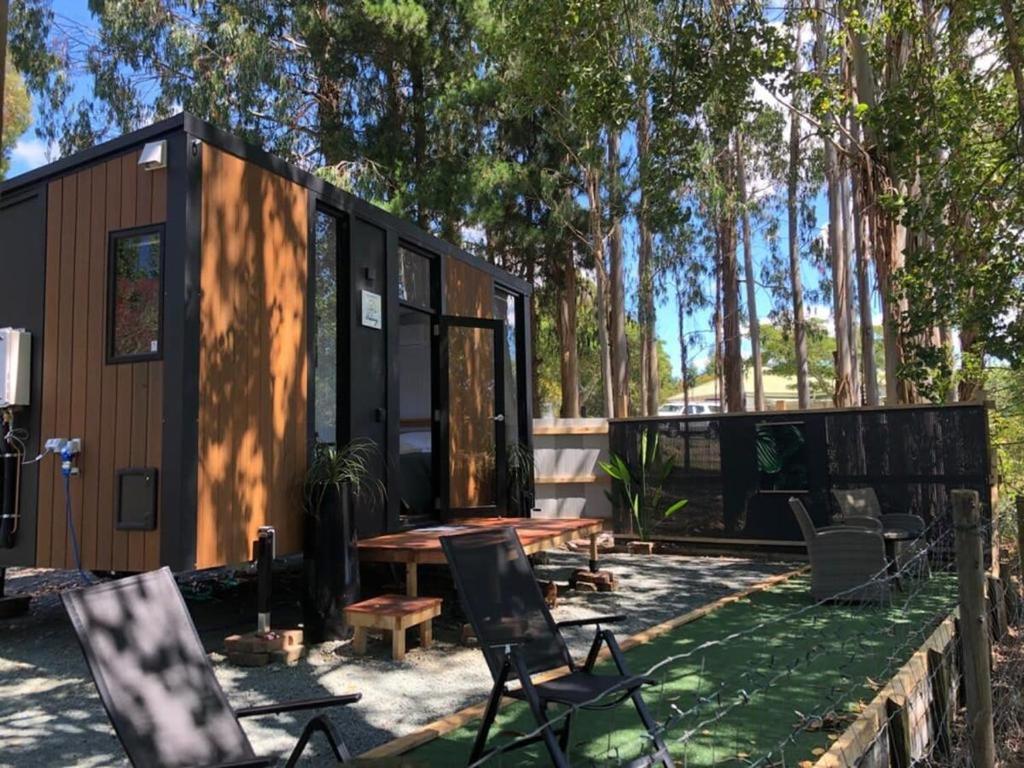 une petite maison dans les bois avec une table et des chaises dans l'établissement The Hide Away Cabin, à Redwoods Valley