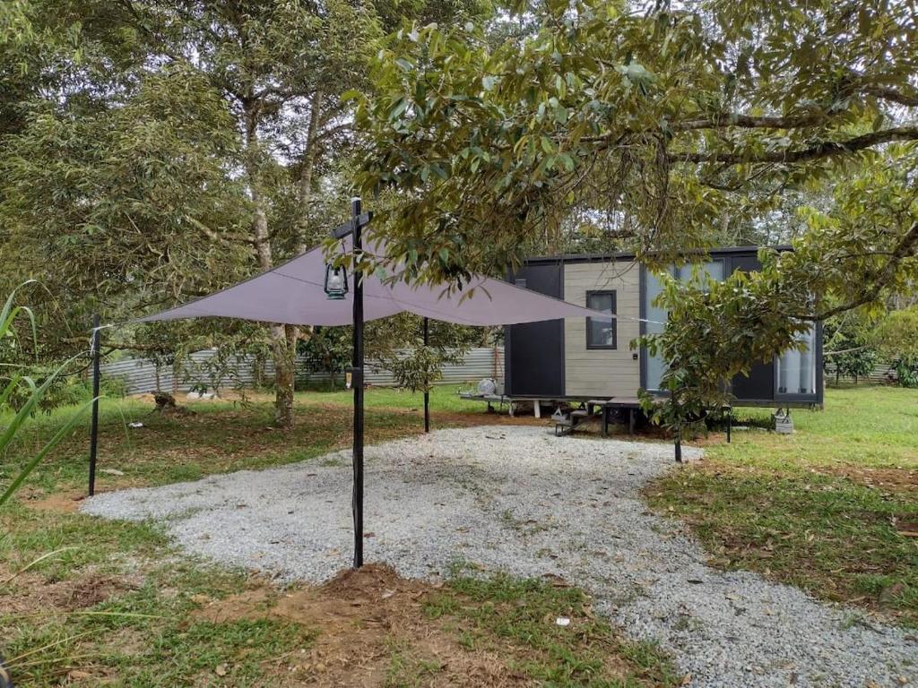 a white umbrella in front of a house at Sungai Tiny House in Raub