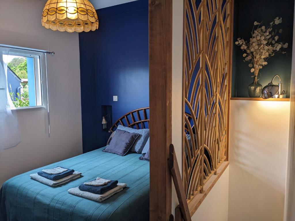 a blue bedroom with a bed with towels on it at La Maison du Cosquer in Camaret-sur-Mer