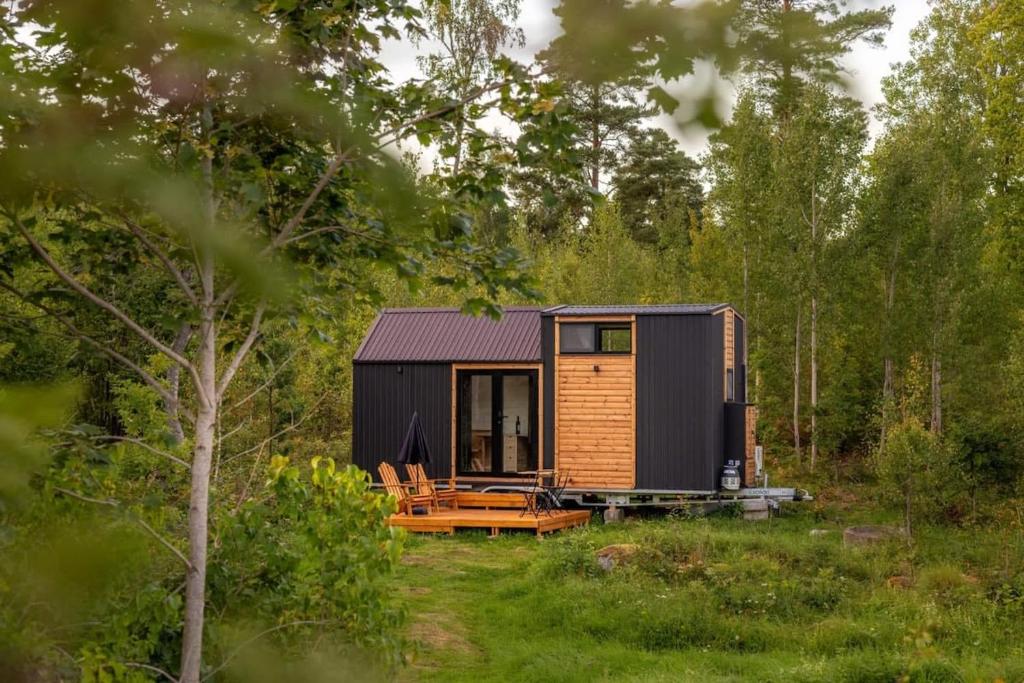 une petite maison dans les bois avec une terrasse dans l'établissement Ammebergs Blommor, à Åmmeberg