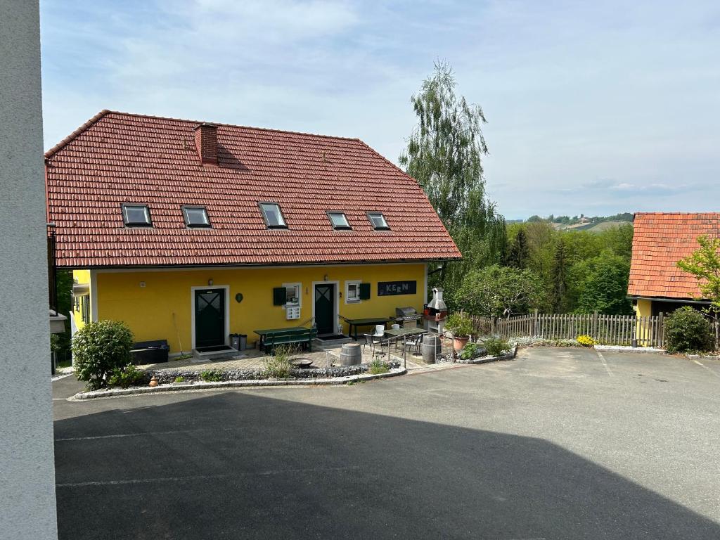 ein gelbes Haus mit rotem Dach auf einer Straße in der Unterkunft Haus-Eckberg 101 in Gamlitz