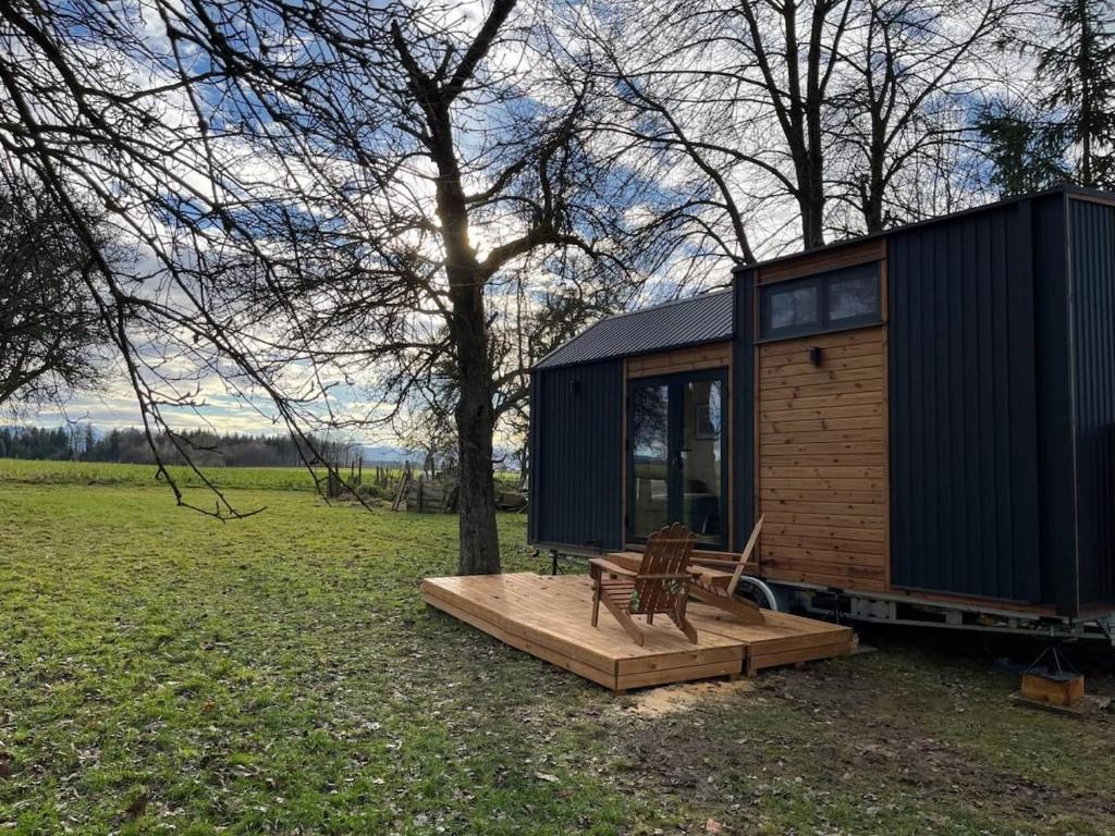 a tiny house with a bench on a wooden deck at Lisi Grun Tiny House in Sattledt