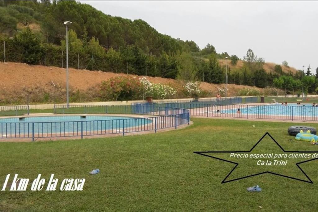 a swimming pool in a park with a grass field at Ca la Trini - turisme rural in Torrellas de Foix