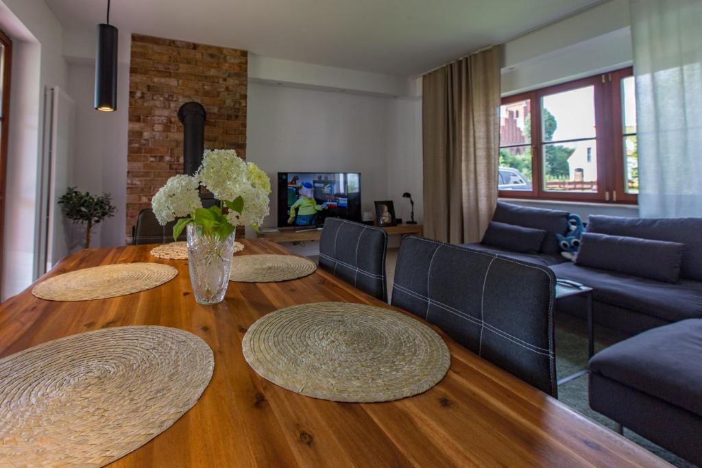 uma sala de estar com uma mesa de madeira e um sofá em Art&Lake House em Pasym