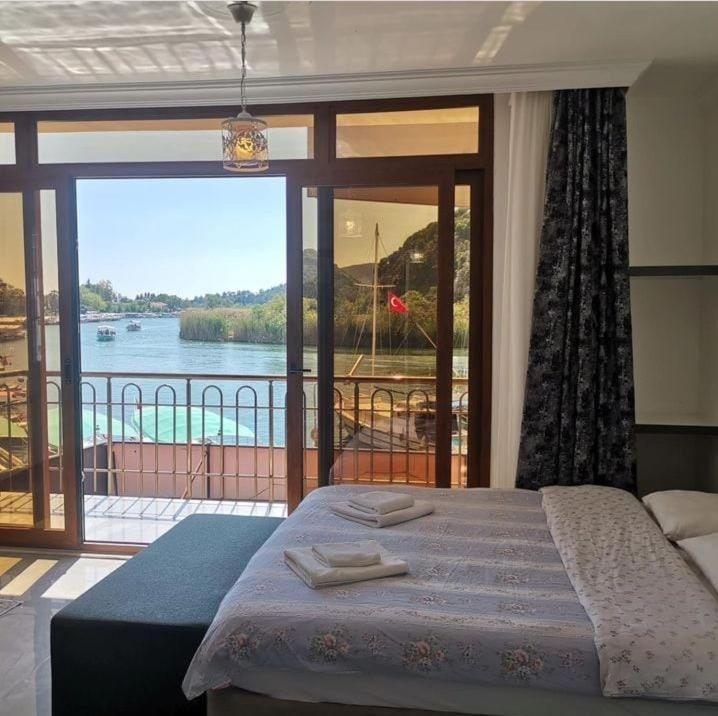 a bedroom with a bed and a view of the water at Aydın Pansiyon in Ortaca