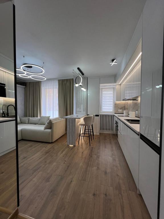 eine Küche und ein Wohnzimmer mit einem Sofa und einem Tisch in der Unterkunft Zeus Ultra Apartament in Baia Mare
