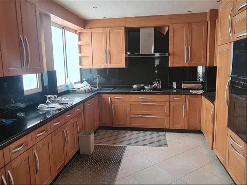 a kitchen with wooden cabinets and black counter tops at Agadir, Simple mais confortable in Agadir