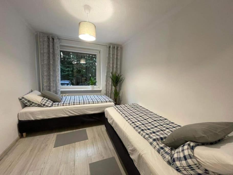 two beds in a room with a window at Forest Apartment, Sopot Mazowiecka st. ! in Sopot