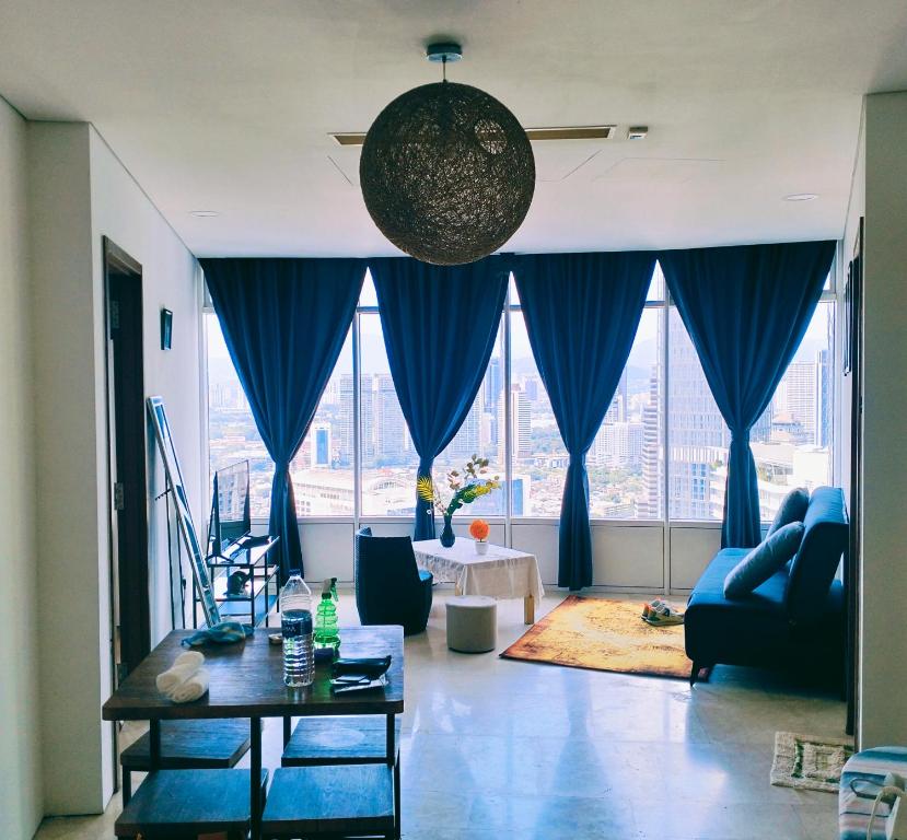 sala de estar con cortinas azules y mesa en Vortex suites klcc by Rahat, en Kuala Lumpur