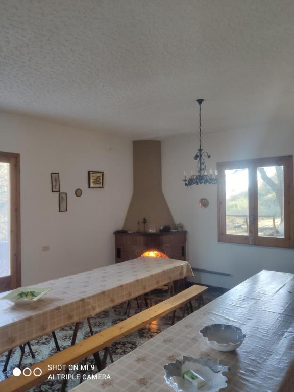 uma sala com mesas de madeira e um fogão em Oasi ristoro dell' Etna em Piedimonte Etneo