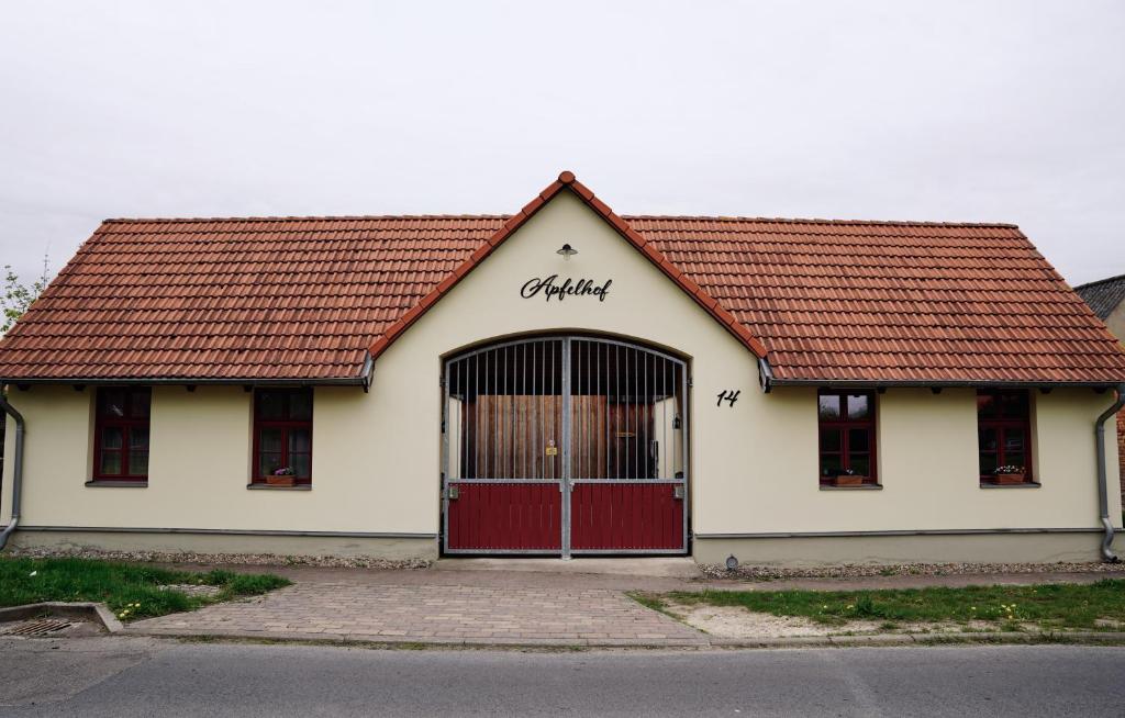 a building with a red door and a red roof at Apfelhof Biesenbrow in Biesenbrow