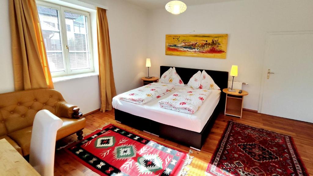 ein kleines Schlafzimmer mit einem Bett und einem Sofa in der Unterkunft Ferienwohnung Stelzl in Sankt Johann im Saggautal