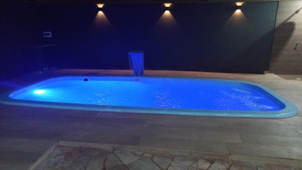 a large blue swimming pool in a dark room at Casa com piscina de 2 dormitórios in Ribeirão Preto