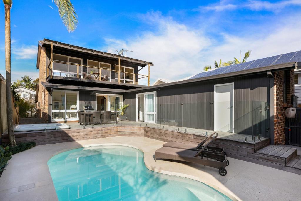 a house with a swimming pool in front of it at Perfect Beach getaway in Narrabeen