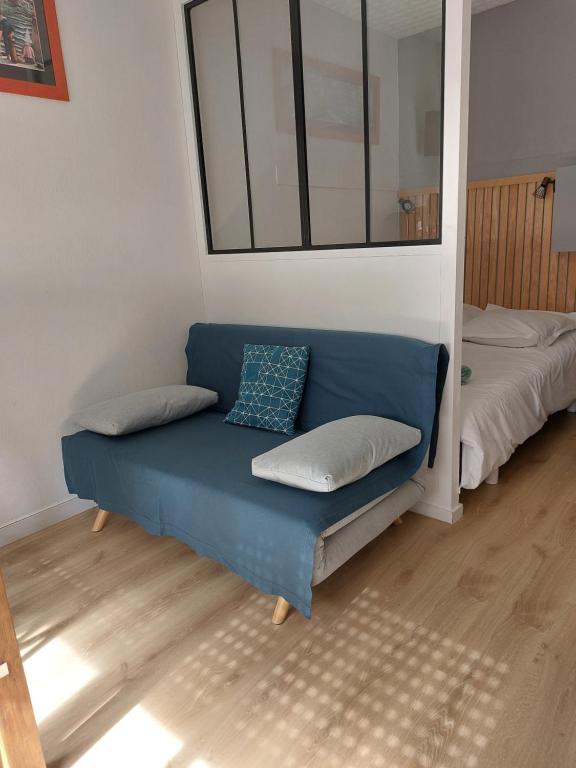 Sofá azul en una habitación con cama en Studio la Salicorne au Sables d'Olonne, en Les Sables-dʼOlonne
