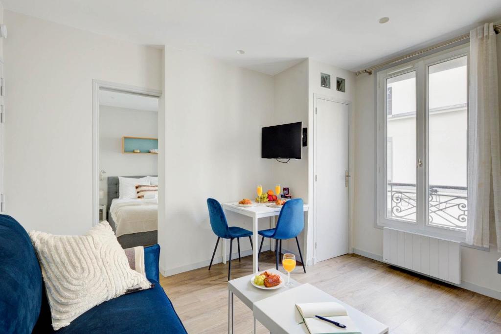 a living room with a blue couch and a table at Invalides & Eiffel Tower - CityApartmentStay in Paris