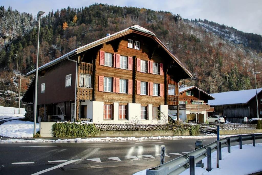 a large wooden house on the side of a road at Alpine chalet apt w/parking and porch in Meiringen