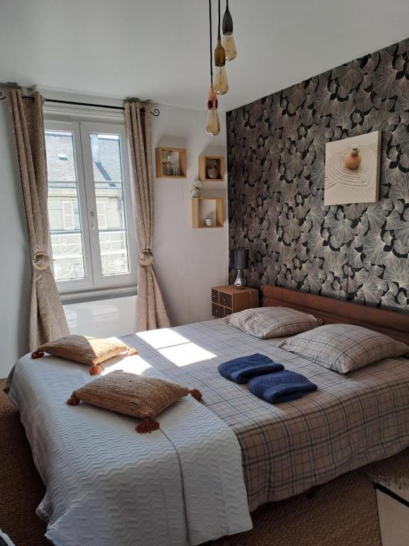 um quarto com uma cama grande e almofadas azuis em Atypique Saumur 80 m2 joli appartement 2 à 7 pers familial rénové entier 3 chambres hyper centre em Saumur