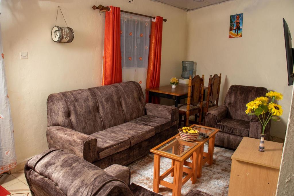 a living room with two couches and a table at Hilda's place in Embu