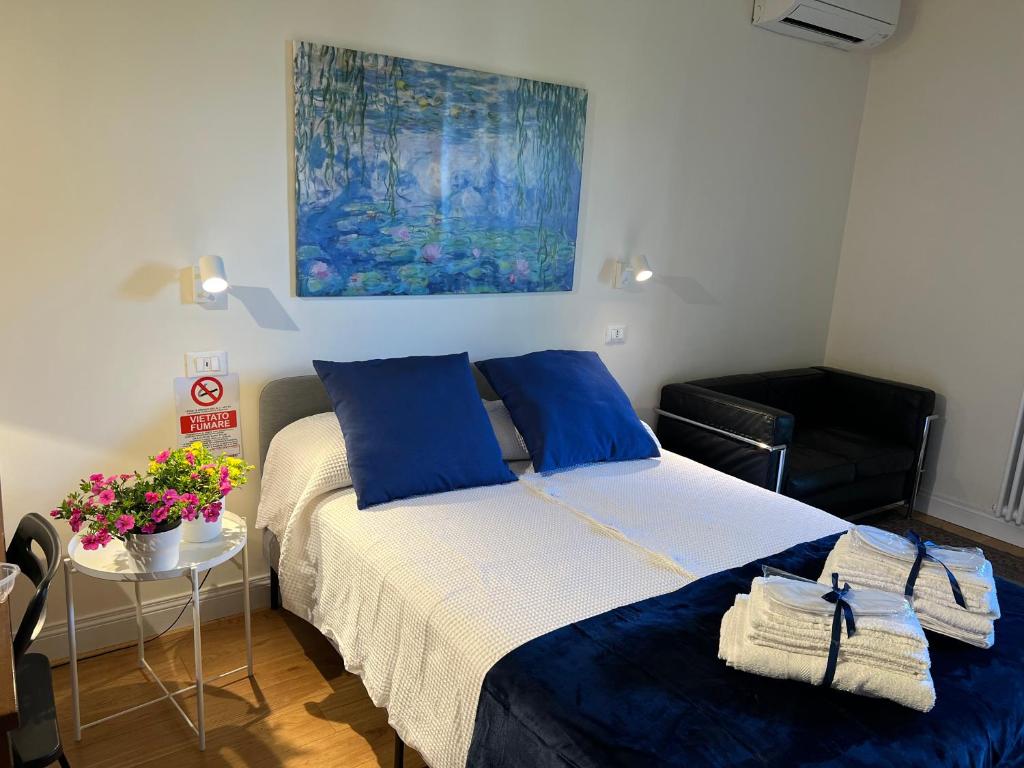 een slaapkamer met een bed met blauwe kussens en een schilderij bij BLU in Marina di Massa