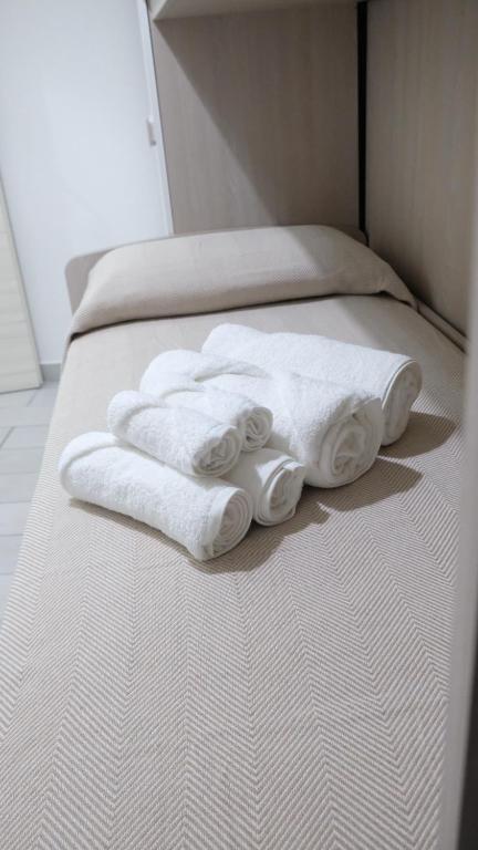 2 weiße Handtücher auf einem Bett liegen bereit. in der Unterkunft Capodichino Hause in Neapel