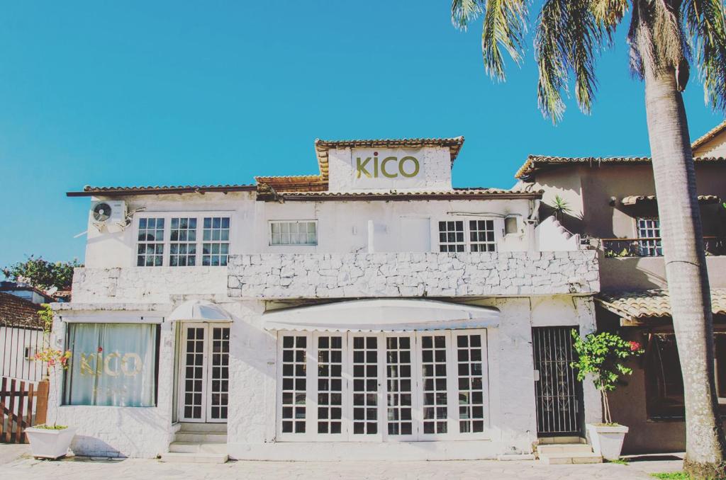 a white building with a kico sign on it at Pousada Kico in Búzios