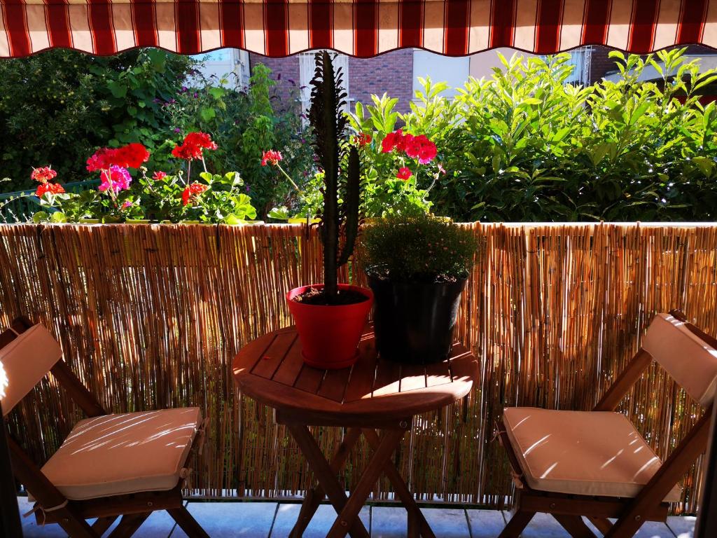 a table with two chairs and a plant on a patio at AUBER Modern big apartment with Parking 12 minutes from Metro in Vitry-sur-Seine